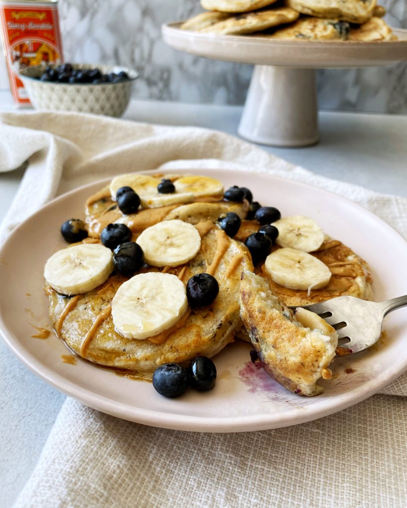 vegan blueberry pancakes with a piece cut out on a fork