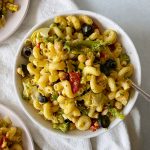 pasta salad in a white bowl on a linen dish rag