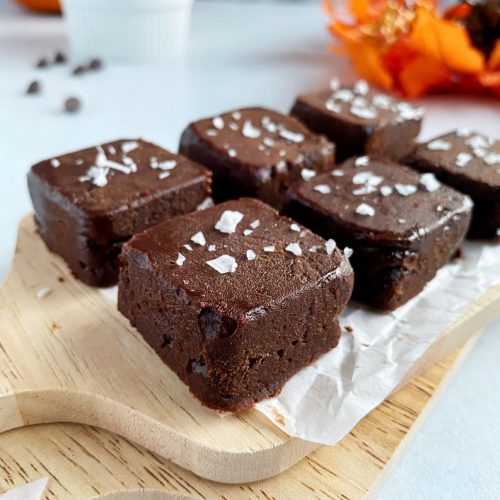 close up of pumpkin peanut butter chocolate fudge on wooden board