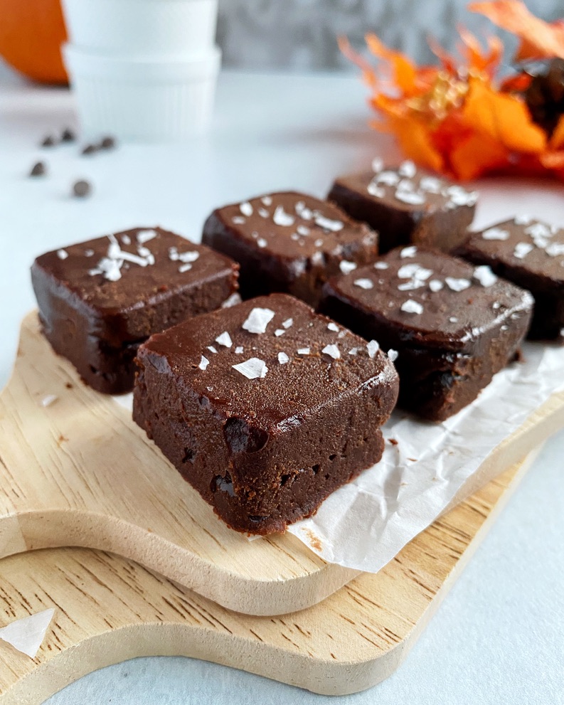 close up of pumpkin peanut butter chocolate fudge on wooden board