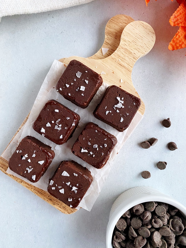 overhead shot of vegan pumpkin peanut butter chocolate fudge on a wooden mini cutting board