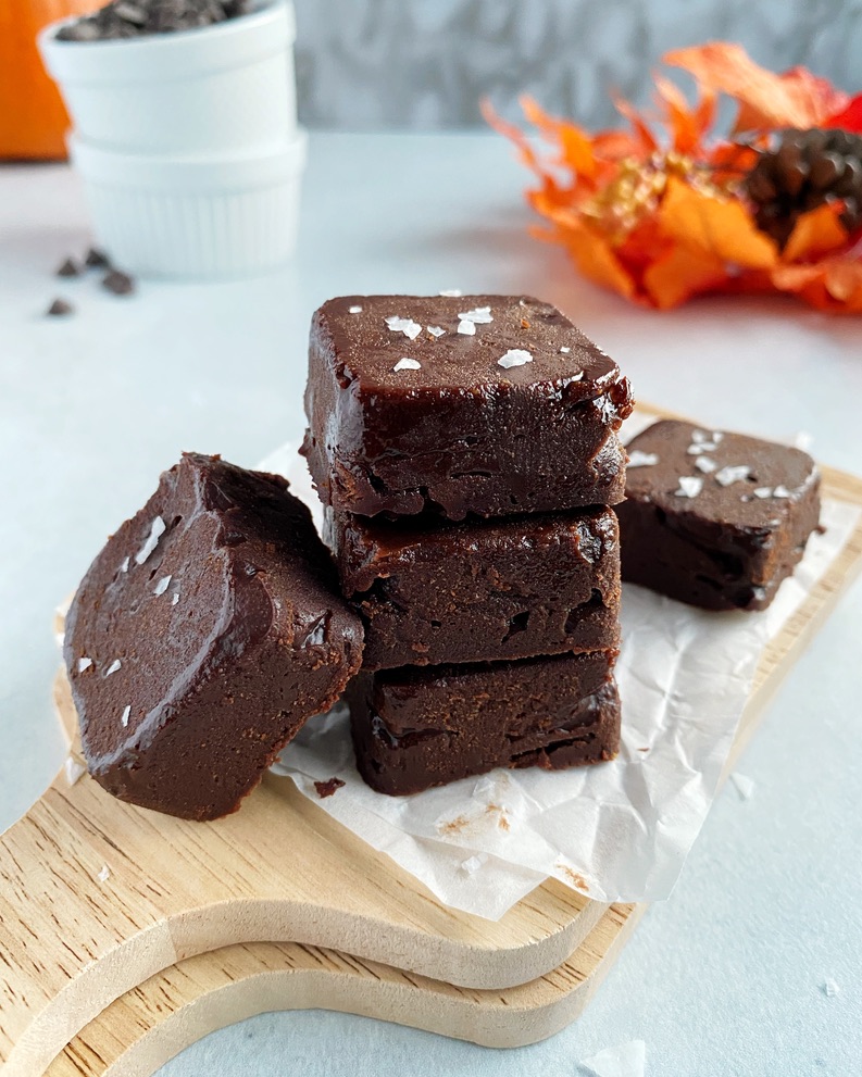 3 pieces of pumpkin peanut butter chocolate fudge  stacked on wooden board