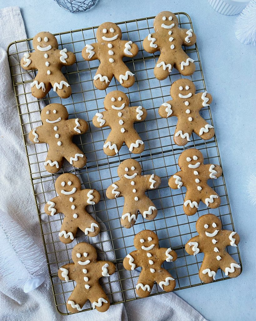 overhead shot of iced gingerbread cookies on a gold cookie rack