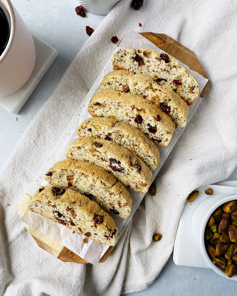 cranberry pistachio biscotti lined up on a marble tray