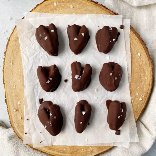 chocolate covered dates on round wood cutting board