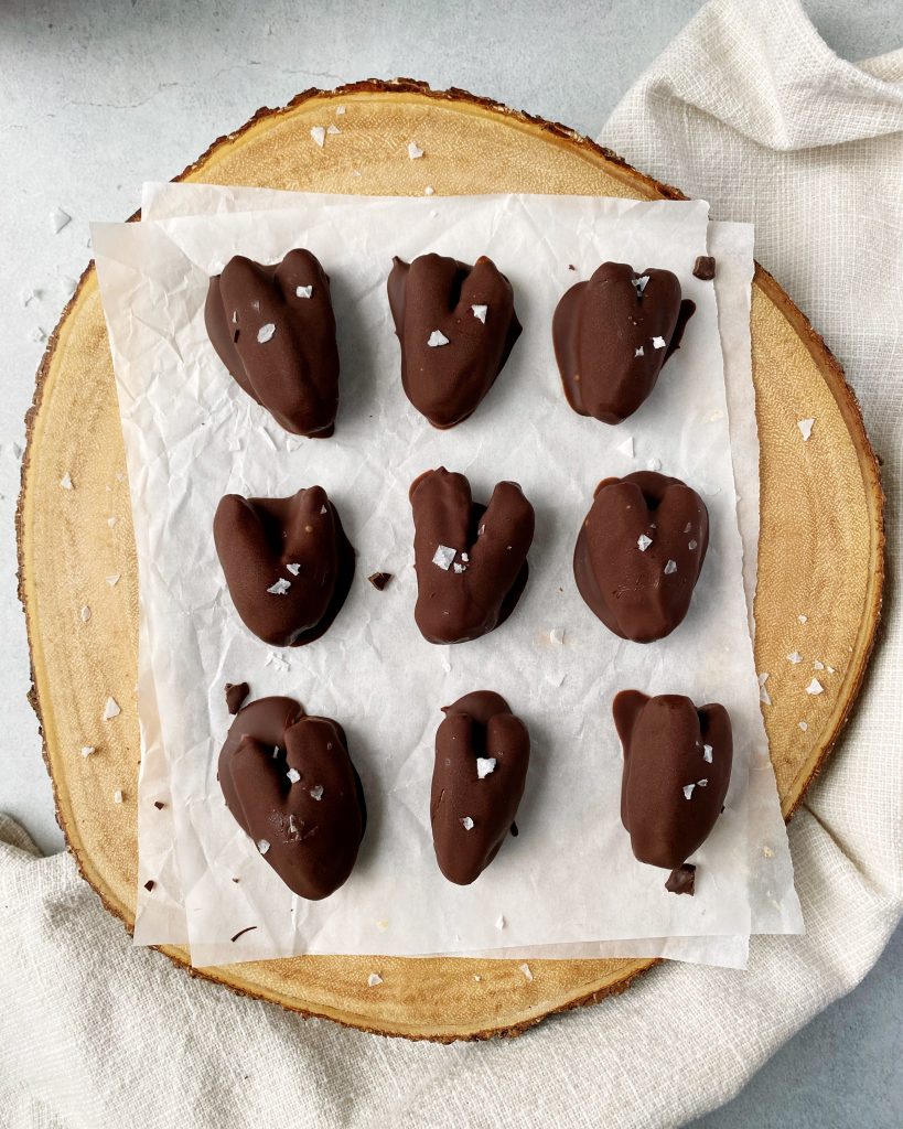 chocolate covered dates on round wood cutting board