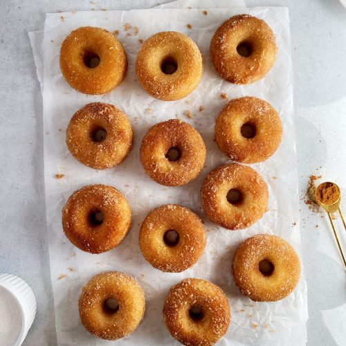 overhead shot of cinnamon sugar donuts on white parchment paper