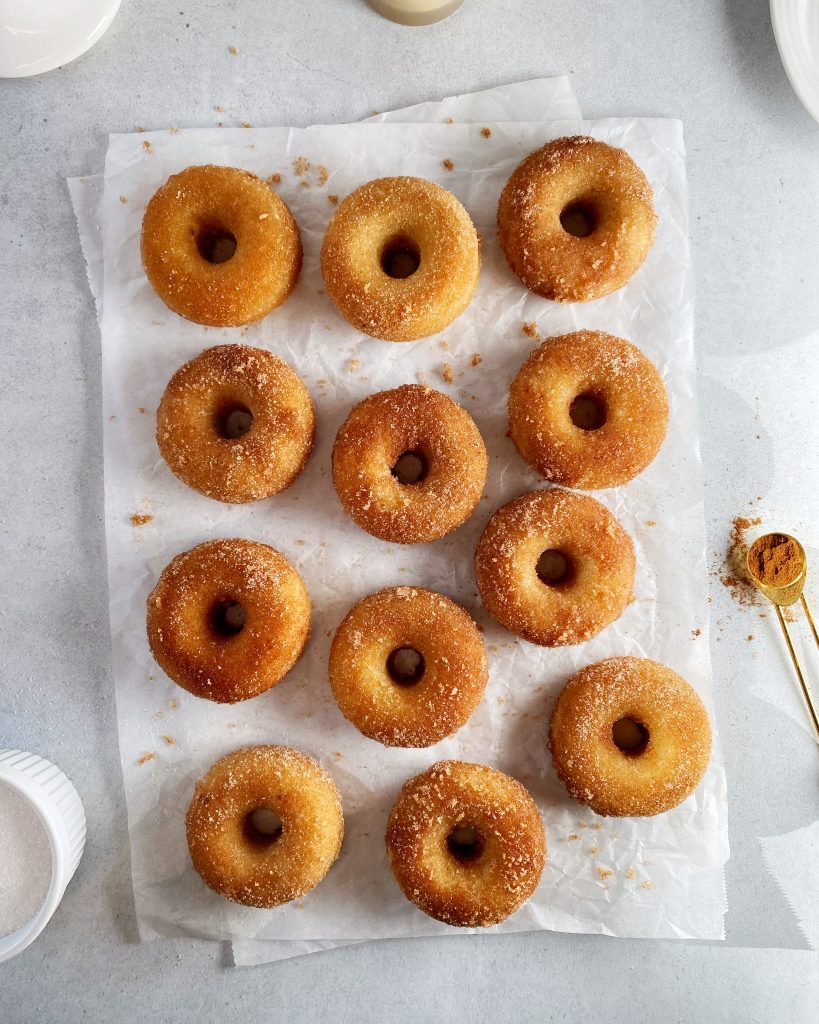 overhead shot of cinnamon sugar donuts on white parchment paper