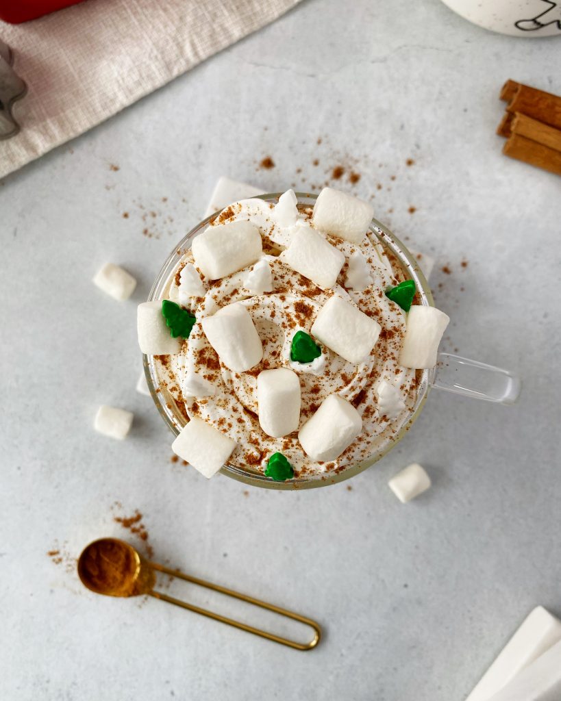 overhead shot of gingerbread latte showing vegan whipped cream, marshmallows, and candied green and white trees