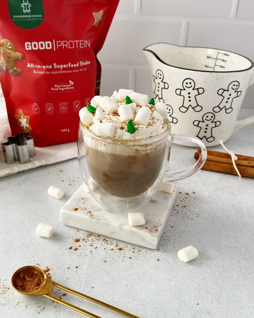 gingerbread latte topped with whipped cream and marshmallows on a square marble coaster
