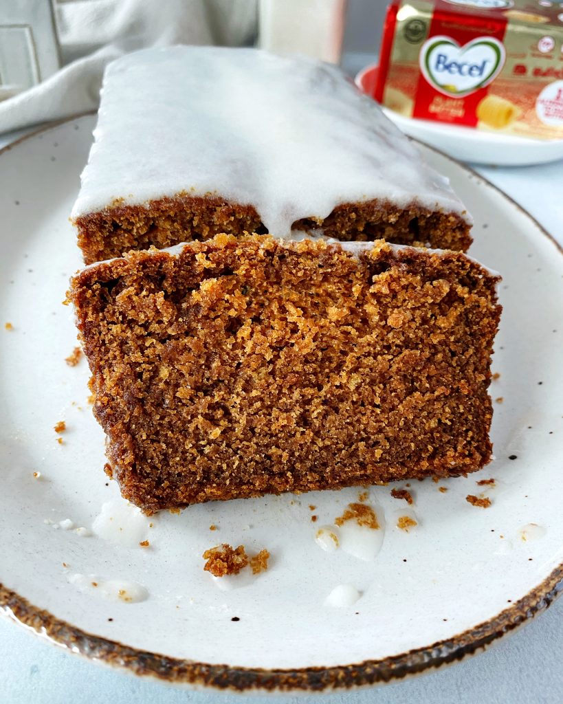 close up of gingerbread loaf on serving tray with one cut piece 