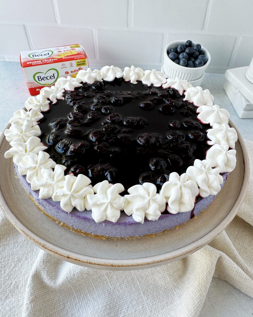 vegan blueberry cheesecake topped with blueberry compote and vegan whipped cream