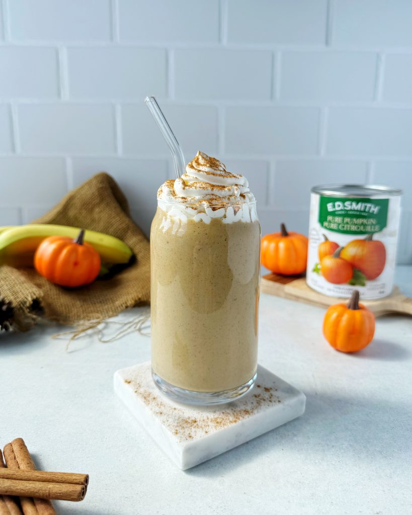 pumpkin smoothie with vegan whipped cream sprinkled with cinnamon