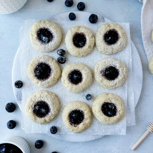 blueberry thumbprint cookies on a marble serving board