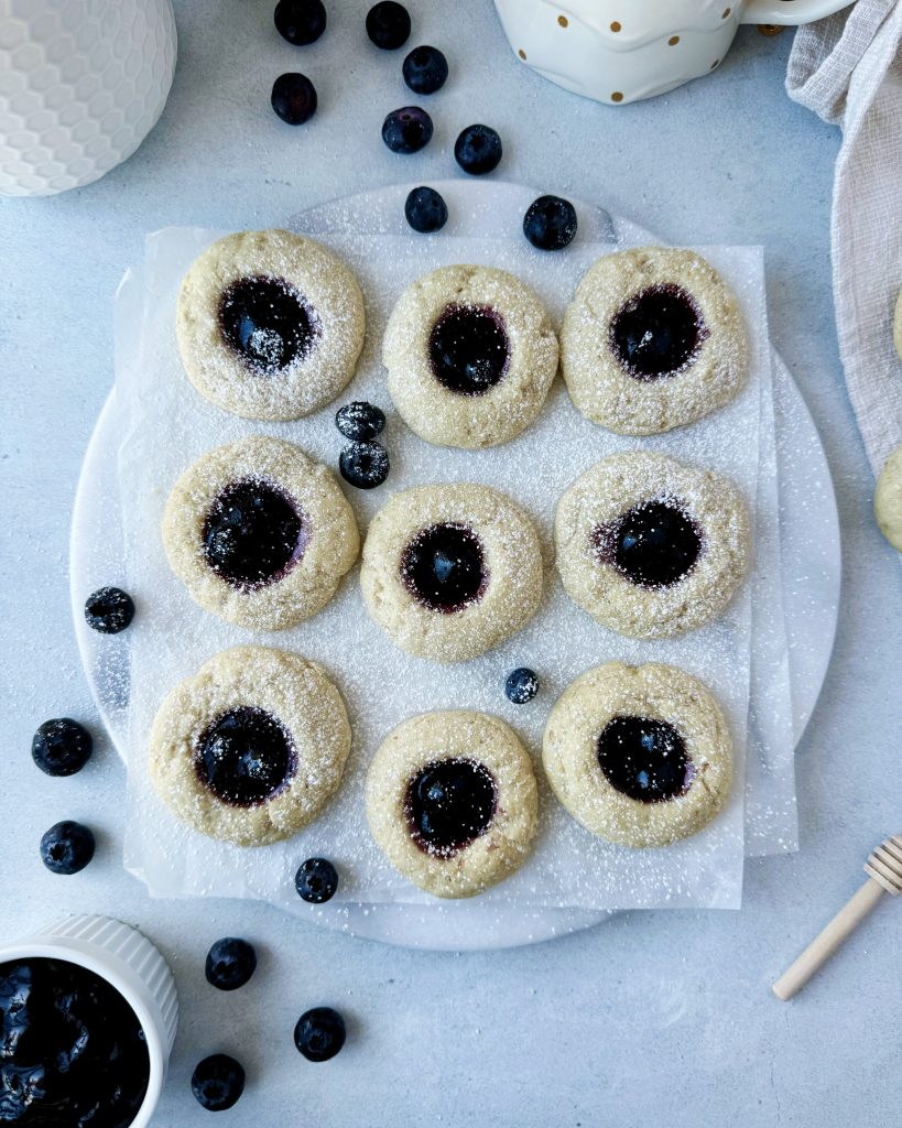 blueberry thumbprint cookies on a marble serving board