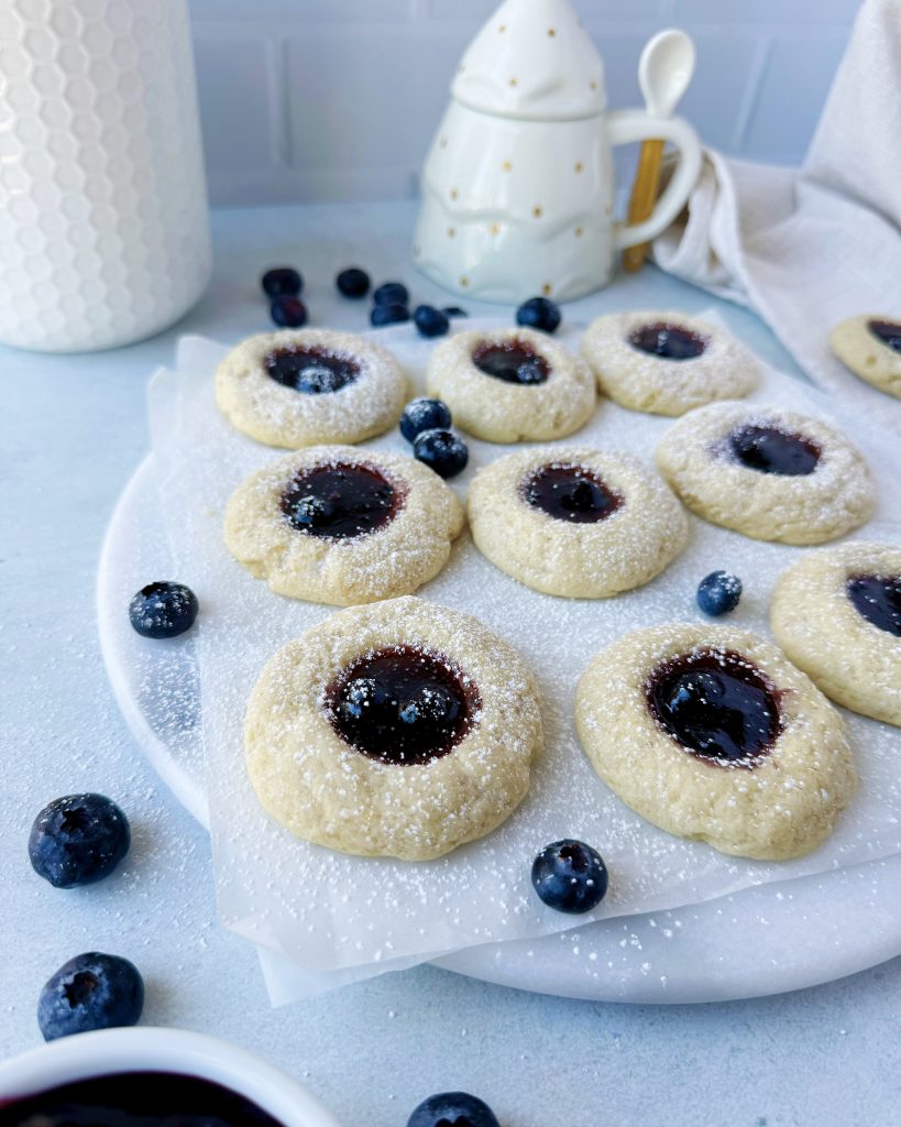 blueberry thumbprint cookies on round marble serving board