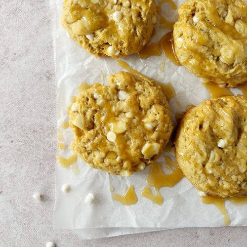 vegan salted caramel cookies on a white parchment paper with caramel drizzle