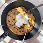 chocolate chip vegan skillet cookie topped with vegan whipped cream