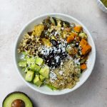 warm salad with roasted vegetables, topped with avocado, walnuts and vegan feta