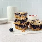 3 blueberry crumble bars stacked on top of each other