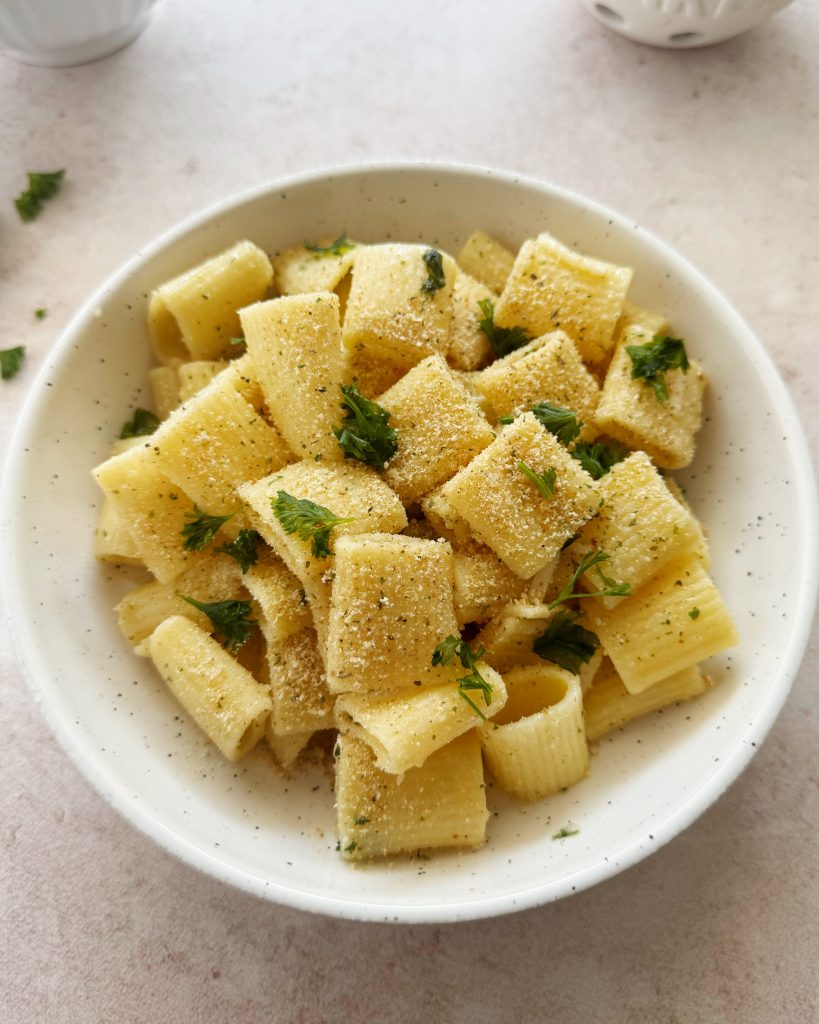 vegan garlic bread pasta topped with breadcrumbs and parsley