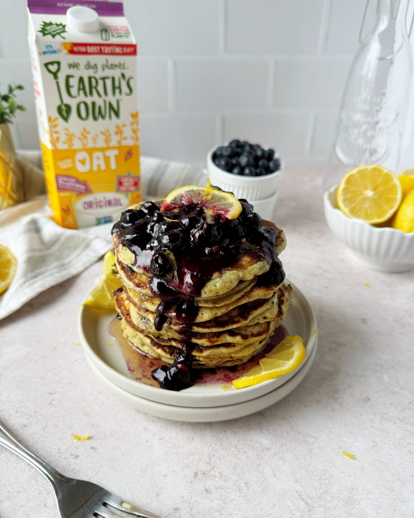 blueberry lemon pancakes stacked on a plate topped with a blueberry compote