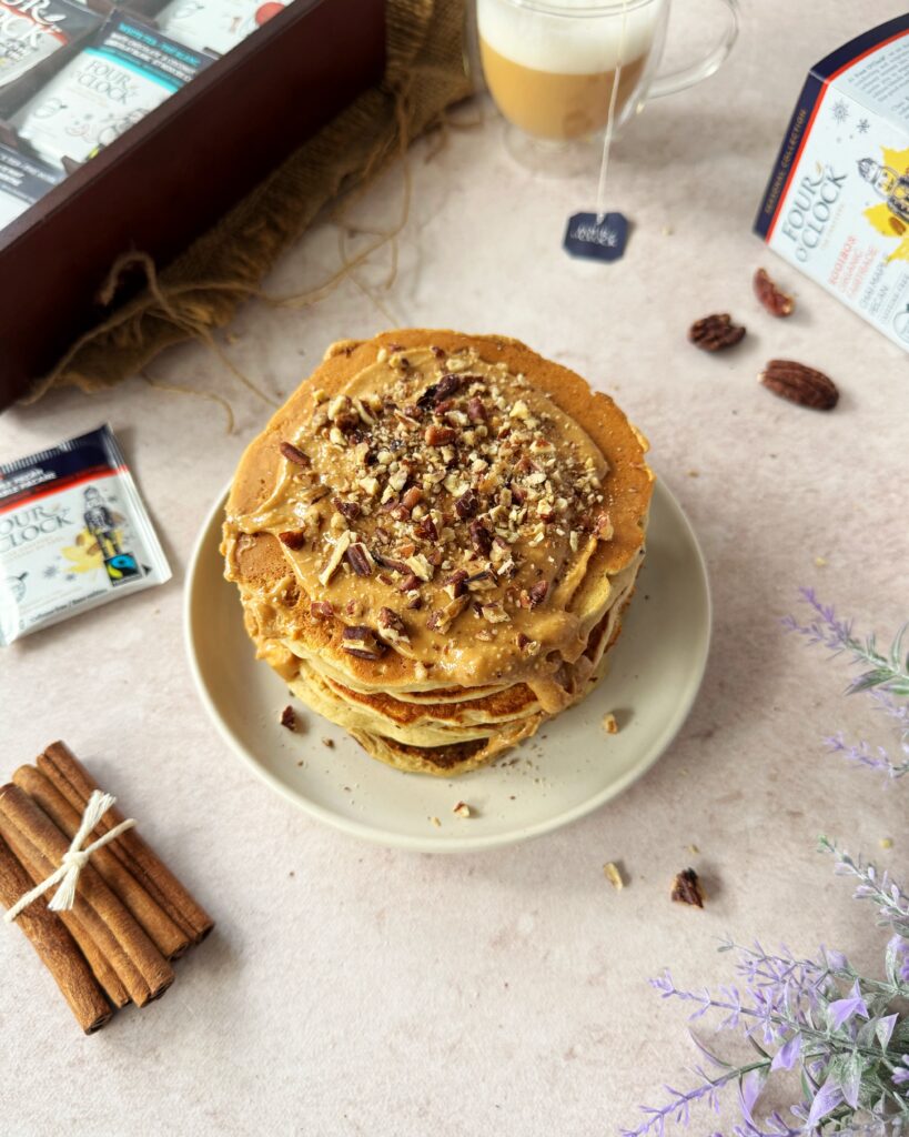 stack of chai maple pecan pancakes with crushed pecans and maple syrup