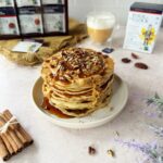 Chai maple pecan pancakes with crushed pecans peanut butter and maple syrup